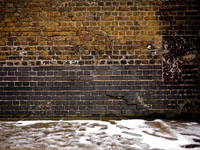 snow in front of old brick wall